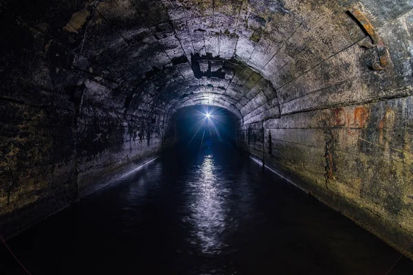 Túnel de la mina de drenaje abovedado de hormigón inundado oscuro — Foto de Stock