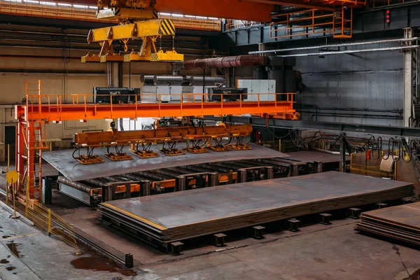 Overhead crane with vacuum handling grippers lifting iron sheets — Stock Photo, Image