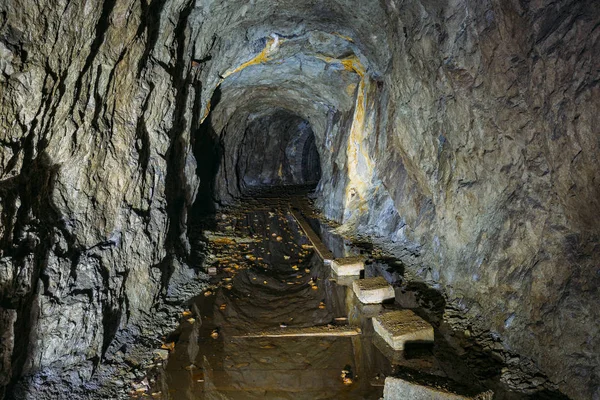 Dark creepy dirty flooded abandoned mine tunnel — Stock Photo, Image