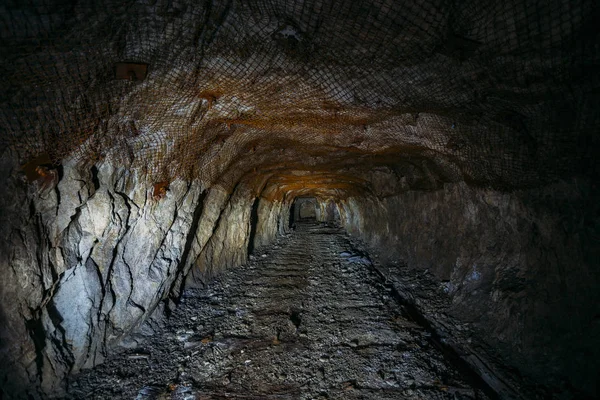 Dark dirty abandoned uranium mine with rusty remnants of railway — Stock Photo, Image