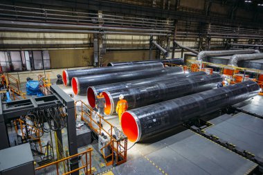 İşçiler fabrikada yeni kaplamalı boru incelemek