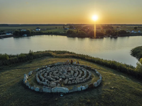 Spirallabyrinth aus Steinen, am See bei Sonnenuntergang — Stockfoto