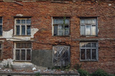 Kırık pencereler ve ahşap kapı ile kırmızı tuğla eski grungy duvar