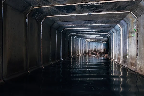 Zaplavený kanalizační tunel se odráží ve vodě. Špinavá městská odpadní voda — Stock fotografie