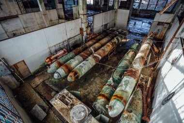 Terk edilmiş torpido fabrikasında eski paslı denizaltı torpidoları