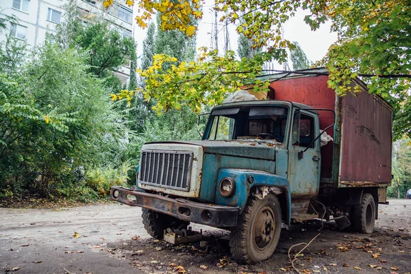 Caminhão enferrujado velho com janelas quebradas na parte overgrown abandonada — Fotografia de Stock