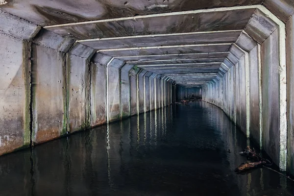 Översvämmade avlopps tunneln reflekteras i vatten. Smutsigt urbant avloppsvatten — Stockfoto