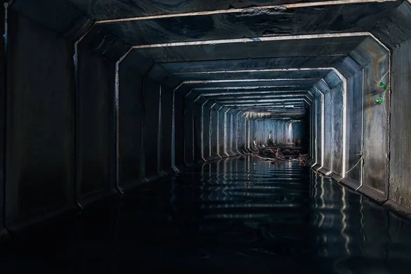 El túnel de alcantarillado inundado se refleja en el agua. Aguas residuales urbanas sucias — Foto de Stock