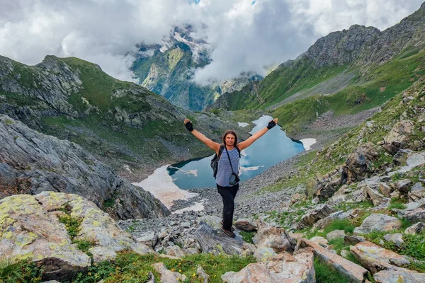 Радісний успішний турист з піднятими обіймами на скелі в горах — стокове фото