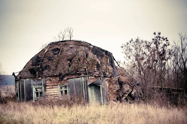 A aldeia russa abandonada. Ruínas da casa rural com ro colmado — Fotografia de Stock