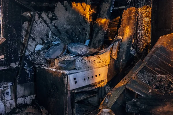 Interior de la casa quemada. Cocina quemada, restos de estufa y muebles — Foto de Stock