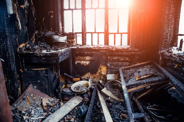 Burnt house interior. Burned kitchen, remains of furniture in bl — Stock Photo, Image