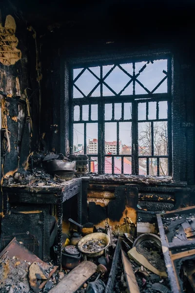 Burnt house interior. Burned kitchen, remains of furniture in bl