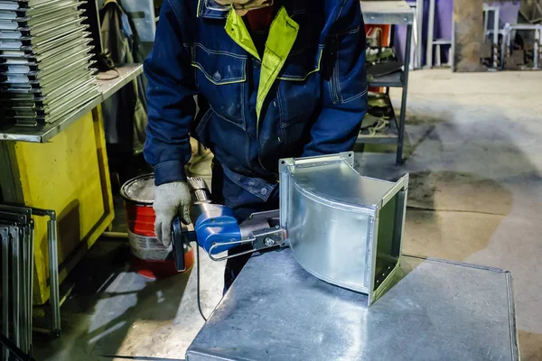 Pracownik w zakładzie obróbki metali instalujący nity w części do c — Zdjęcie stockowe
