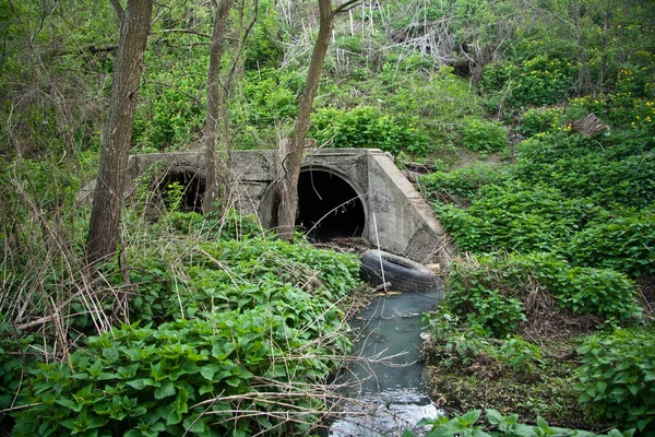 Dirty sewage stream flowing from sewer tunnel
