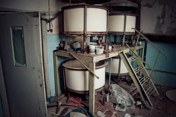 Old rusty small vats in abandoned chemical factory