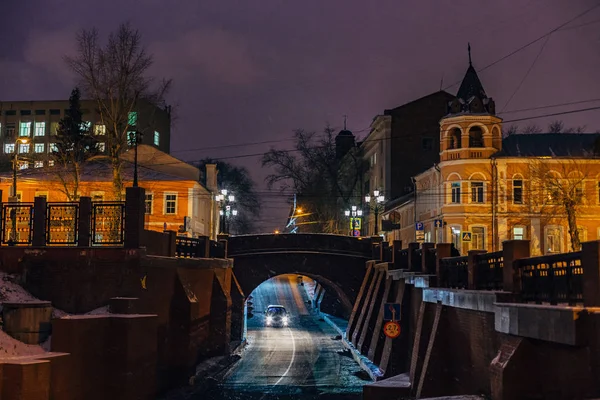 Night winter Voronezh, auto beweegt op de weg onder stenen brug. — Stockfoto