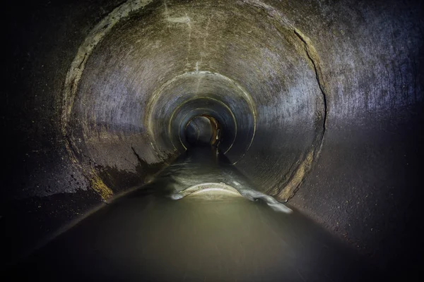 Rivière souterraine d'eaux usées industrielles se déversant dans les égouts ronds — Photo
