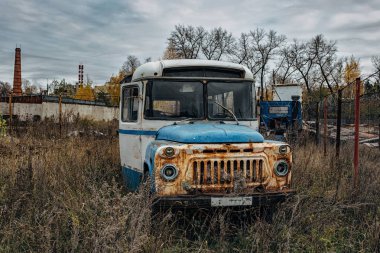 Soğuk bulutlu sanayi bölgesinde eski paslı terk Edilmiş Sovyet otobüsü