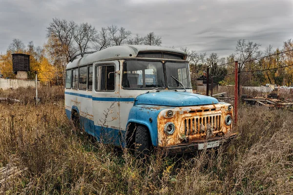 Alter rostiger verlassener sowjetischer Bus im Industriegebiet in kalter Bewölkung — Stockfoto