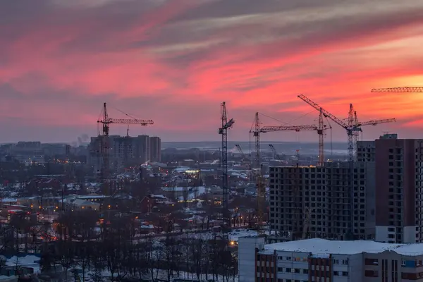 High-rise buildings construction site on crimson sunset sky back — Stock Photo, Image