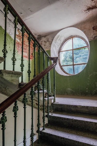 Stare zabytkowe schody w starym domu. Okno owalne — Zdjęcie stockowe