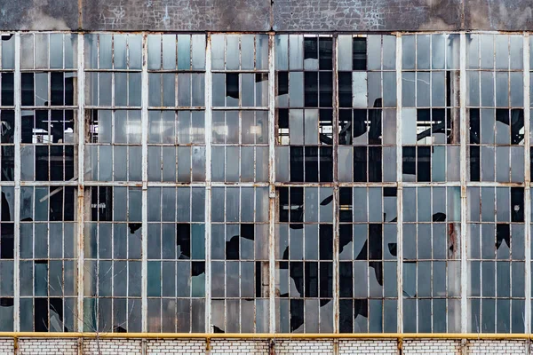 Janelas partidas num antigo edifício industrial abandonado — Fotografia de Stock