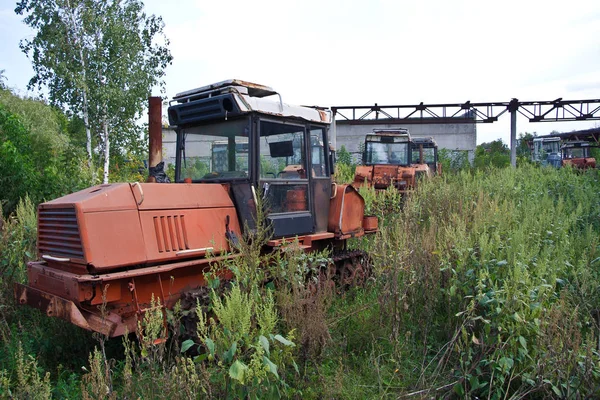 Verlaten roestige overwoekerde Caterpillar tractoren — Stockfoto