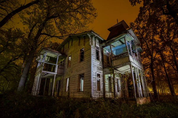 Old creepy wooden abandoned haunted mansion at night — Stock Photo, Image