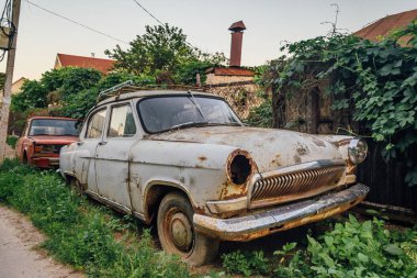 Eski paslı ve yıpranmış hurda araba karanlık tarafında eski sokakta