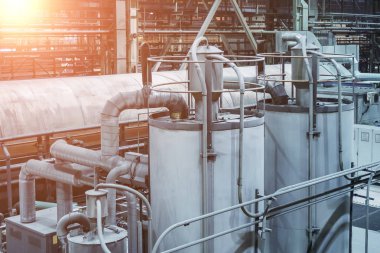 Fabrika atölyesinde boru hatlarıyla bağlanan çelik tanklar