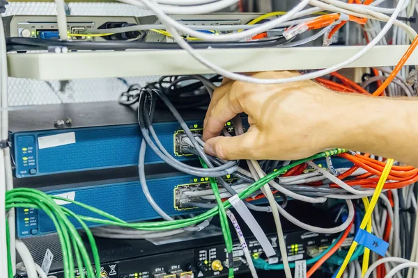 Inżynier łączący przewód sieciowy w celu przełączenia piasty światłowodowej f — Zdjęcie stockowe