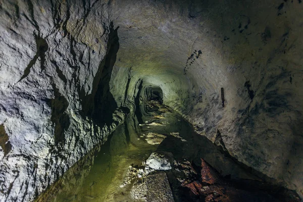 Reflejos de agua dentro de la oscura mina abandonada inundada sucia — Foto de Stock