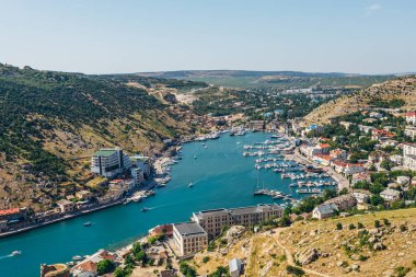 Açık güneşli yaz gününde Karadeniz kıyıları ve şehir Balaklava güzel havadan görünümü. Balaklava Körfezi, Kırım