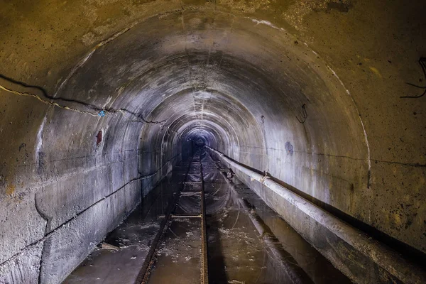 Túnel de mina subterránea inundado abandonado con tubería y estrecho-g — Foto de Stock