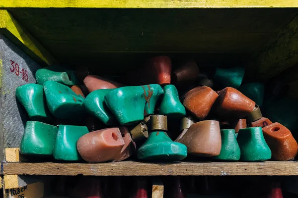 Almofadas de sapato plásticas multicoloridas velhas em prateleiras — Fotografia de Stock