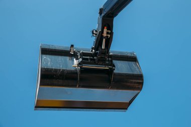 Mavi gökyüzü arka planda ekskavatör kovası