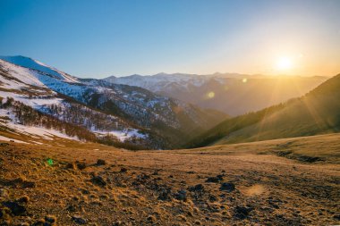 Kafkas dağlarında kar şapkalarıyla güzel bir akşam günbatımı, 