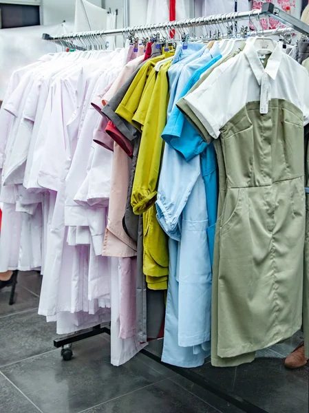 Batas médicas blancas y de colores en perchas — Foto de Stock