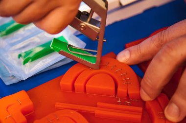 Demonstration of modern medical skin stapler on silicon sample clipart