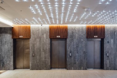 Modern otel lobisinde üç asansör kapalı.