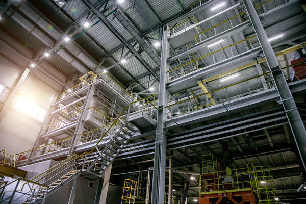 Inside modern Chemical factory production line. Industrial equipment, cables, vats and piping.