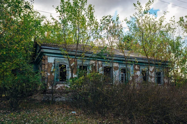 Εγκαταλειμμένο κατεστραμμένο κατάφυτο σπίτι σε εγκαταλελειμμένο ρωσικό χωριό — Φωτογραφία Αρχείου