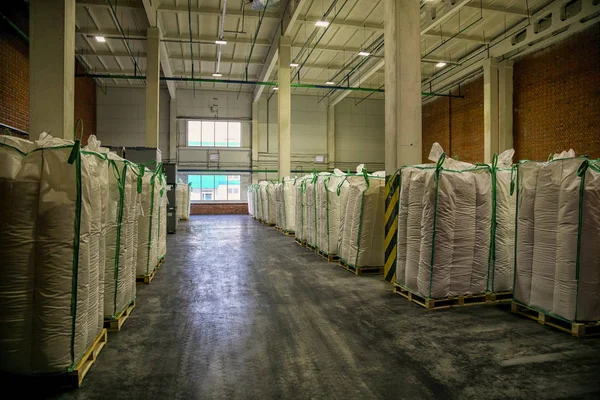 Büyük beyaz sanayi torbalarıyla dolu bir hangar deposu. 