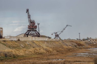 Consequences of Aral sea catastrophe. Abandoned port with rusty  clipart