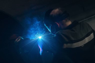 Fabrikada koruyucu maske kaynak borusunda çalışan