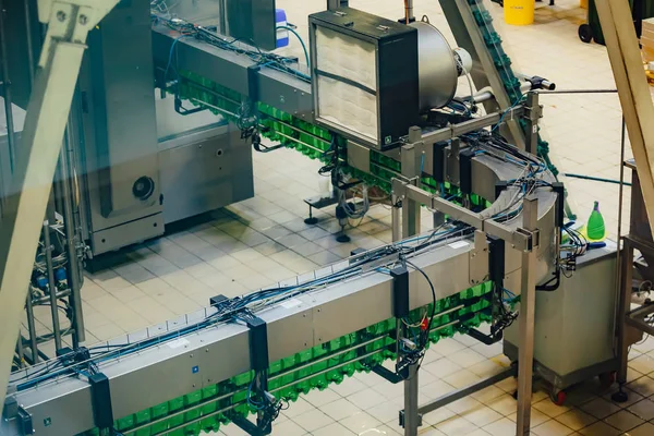 Automated beer bottling production line. Empty beer bottles on c