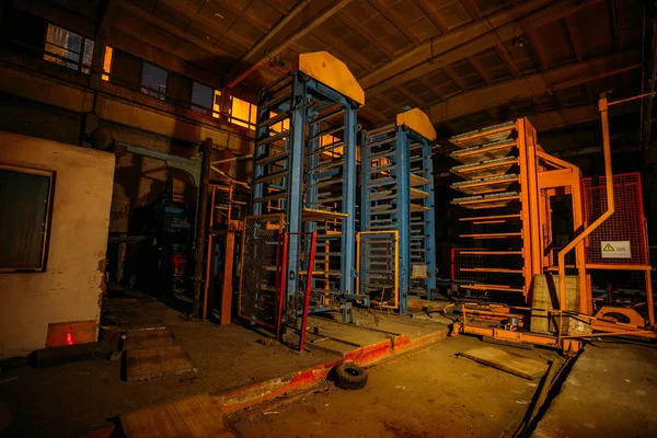 Abandoned brick and paving slabs factory at night. Old rusty machinery — Stock Photo, Image