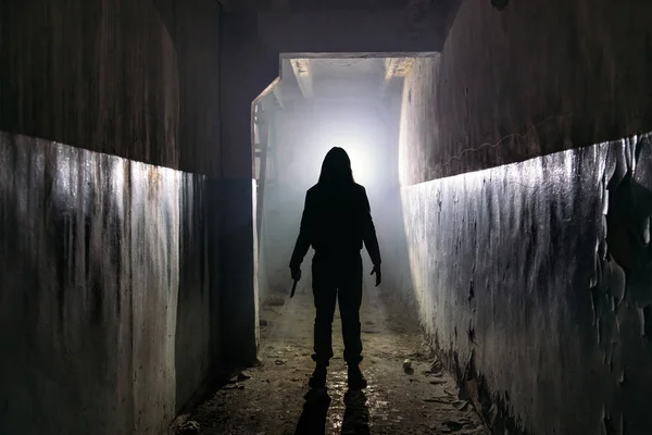 Silhueta assustador de homem desconhecido com faca no escuro abandonado bu — Fotografia de Stock