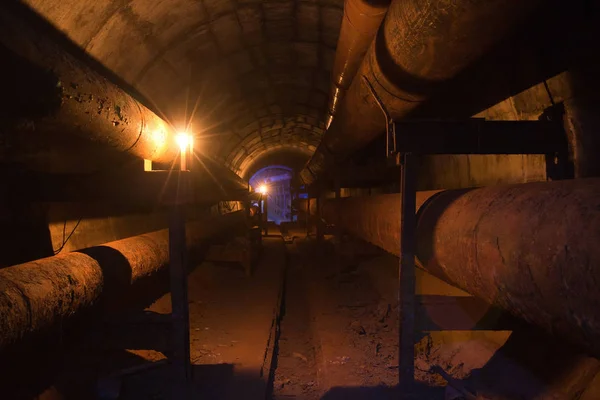 Круглый подземный туннель теплотрассы с ржавыми трубами — стоковое фото